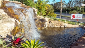 Een waterval met een bordje voor Hotel Supreme Choice.