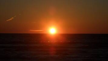 Tramonto sull'oceano, con il sole basso all'orizzonte.