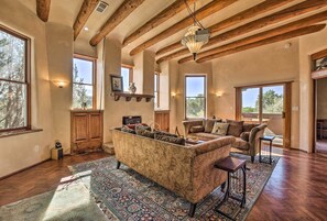 A spacious living room with wooden beams, large windows, and a sofa. - Stunning Santa Fe SW-Style Getaway w/ Indoor Pool! (Santa Fe)