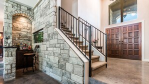 A stone staircase with a metal railing leading to a wooden door. - Lake Travis Acreage with Hilltop Views  (Austin)