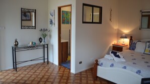 Une chambre à coucher comprenant un lit, une table de chevet, une lampe et une petite table ornée d’objets décoratifs.