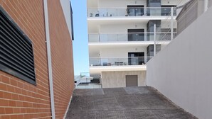 A narrow alleyway between buildings with a brick wall on the left and a white wall on the right. - Tahiti- Spacious, Private Parking, Terrace with Sunbeds, 300 meters Beach (Quarteira)