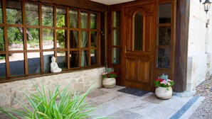 A stone facade with a wooden door and windows.