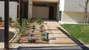 A building entrance with a concrete pathway, small shrubs, and a door labeled "LAUREN 10". - Modern, accessible ground floor apartment just 30 minutes from Murcia airport (Corvera, Murcia)