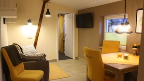 En matplats med ett bord, stolar och en tv som är monterad på väggen.