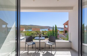 Relax on the balcony with unobstructed views of the coastal landscape and distant hills.