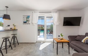 Relax in a spacious living area with a sofa, bar counter, and flat-screen TV.