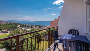 A balcony with a table and chairs, overlooking a coastal town and a bridge. - Nice apartment in Crikvenica with house sea view (Crikvenica)