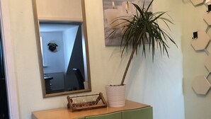 A green dresser with a mirror, a potted plant, and a framed picture on the wall. - Apartment Lichtblick near Centro  (Oberhausen)