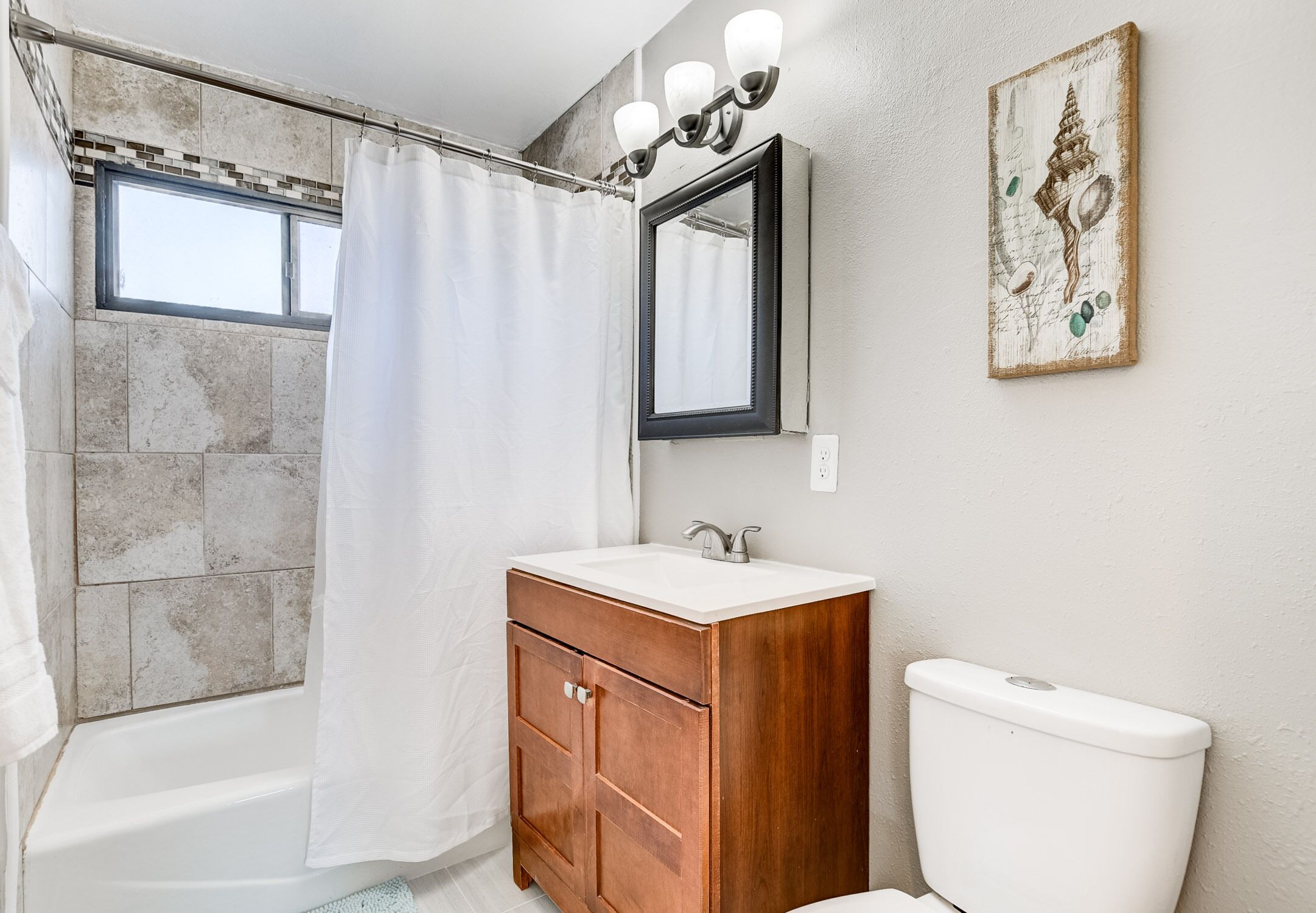 Un baño con bañera, lavabo e inodoro.