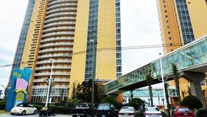 Un hôtel de grande hauteur à la façade incurvée, doté de nombreux balcons et arborant un logo distinctif sur la tour centrale.