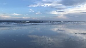 Une plage avec une mer calme et un ciel dégagé.