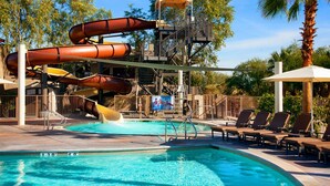 A pool with multiple slides and a canopy structure.