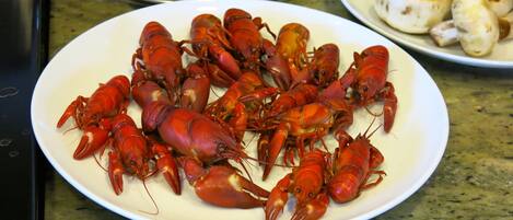A plate of cooked crayfish on a kitchen counter.