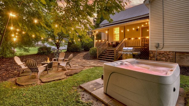 A patio area with outdoor seating, a hot tub, and string lights. - Blue Ridge- Hot Tub - EV Outlet -Outdoor Oasis (Blue Ridge)