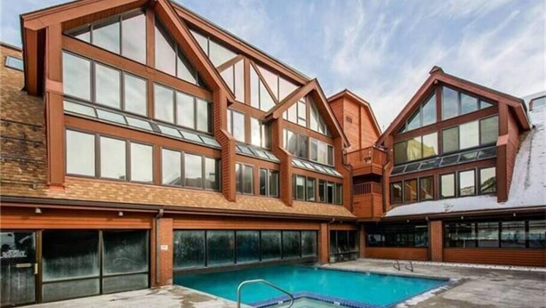 Un bâtiment moderne doté de grandes fenêtres et d’une piscine.