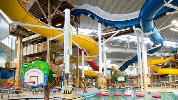 Un parque acuático interior con varias toboganes y una zona de piscina.
