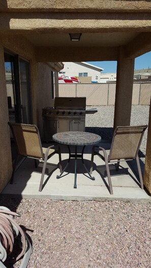 An outdoor patio with a grill, two chairs, and a table. - snowbirds email of call for winter pricing<br>951-741-7590 occapt@hotmail.com (Lake Havasu City)