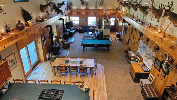 A spacious living area with a pool table, wooden furniture, and mounted animal heads on the walls. - MCR  is a property that features seclusion and privacy that is hard to find.  (Rushford)