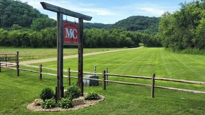 A sign for Money Creek Ranch with a wooden fence and a grassy field. - MCR  is a property that features seclusion and privacy that is hard to find.  (Rushford)