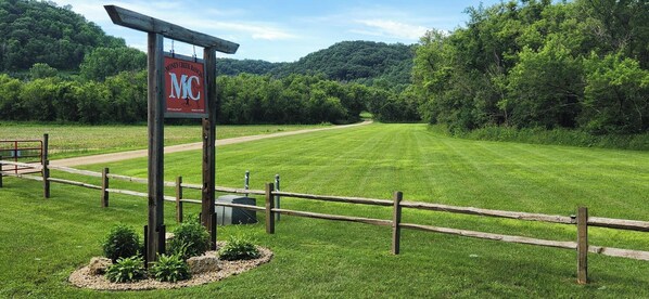 A sign for Money Creek Ranch with a wooden fence and a grassy field. - MCR  is a property that features seclusion and privacy that is hard to find.  (Rushford)