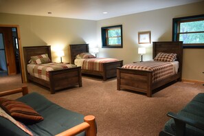 A bedroom with two single beds, a sofa, and a chair. - MCR  is a property that features seclusion and privacy that is hard to find.  (Rushford)