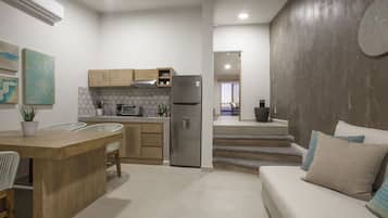 A modern kitchen with wooden cabinets, a stainless steel refrigerator, and a dining area with a wooden table and chairs.