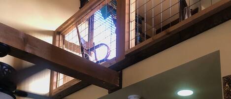 A multi-level interior with a staircase, a door, and a ceiling fan.