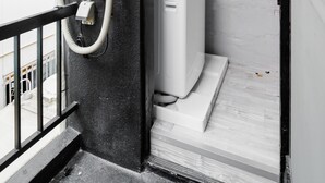 A utility room with a water heater, pipes, and a control panel.
