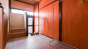 A room with wooden flooring, a staircase, and orange walls.