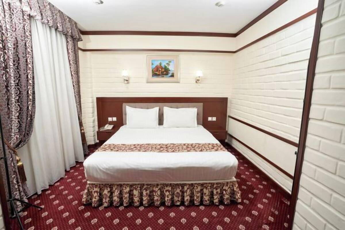 أغطية فراش متميزة وخزنة داخل الغرفة ومكتب وستائر تعتيم