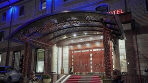 A hotel entrance with a grand archway, a red carpet, and steps leading to the door. - Rakat Plaza (Tashkent)