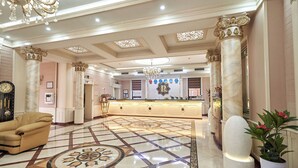 A spacious lobby with a marble floor, a reception desk, and a chandelier. - Rakat Plaza (Tashkent)
