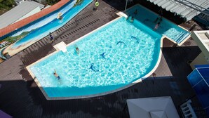 A swimming pool with a wooden deck and a mural on the adjacent wall. - Anh Nguyet Hotel (An Xuyen)