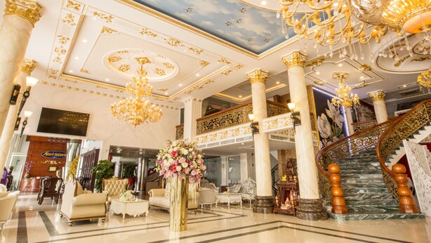 A grand lobby with marble columns, a grand staircase, and ornate chandeliers. - Anh Nguyet Hotel (An Xuyen)