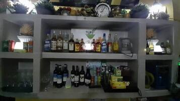 Un'area bar con scaffali pieni di bottiglie di liquore e un orologio appeso al muro.