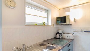 Una cocina moderna con un lavamanos de acero inoxidable, una estufa y un microondas.