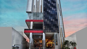 Un bâtiment moderne doté d’une architecture originale, comprenant plusieurs niveaux et combinant des éléments en verre et des panneaux sombres.