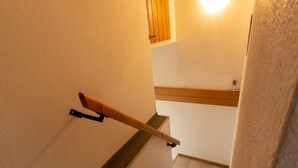 Eine Treppe mit einer Holzhandläufe und einer Holztür oben.