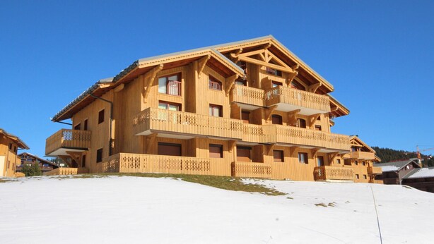 A multi-story wooden chalet with balconies, set against a clear blue sky. - 3-room Apartment Les Saisies, 6 pers, balcony, 2 baths, ski locker (Les Saisies)