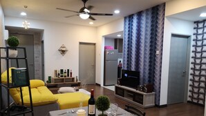 A modern living room with a dining area, a ceiling fan, and a TV on a stand. - Silk Sky Residence (Seri Kembangan)