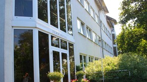 Un immeuble avec une enseigne indiquant « Turm Hotel » et de grandes fenêtres. Des plantes en pot sont disposées à l’extérieur.