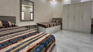 A bedroom with two beds, a wardrobe, a mirror, and an air conditioning unit. - VM Hostel (Ganja)