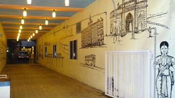 A corridor with a mural of the Taj Mahal and a statue of a woman.