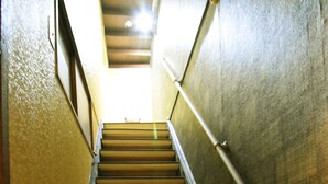 Una escalera con escalones de madera y barandillas metálicas que asciende.