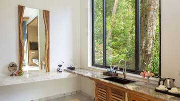 A modern kitchen with a large window, a built-in sink, and a marble countertop.