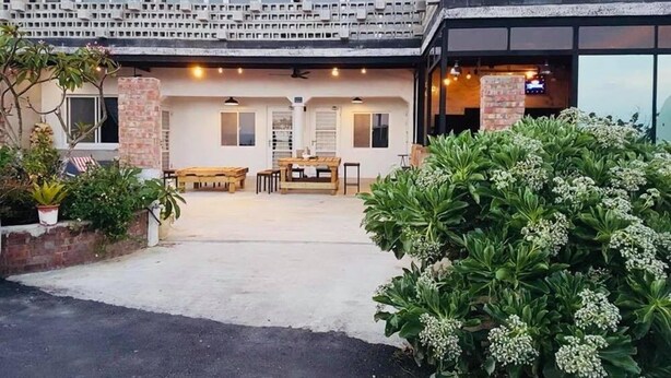 A modern building with a covered outdoor seating area, a brick column, and a large window. - Kenting Sky Villa (Hengchun)