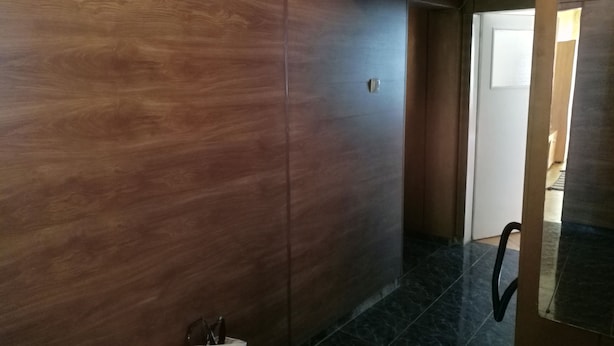 Ein Korridor mit Holzwandverkleidung und einer Tür zu einem anderen Raum.