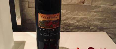 A bottle of Col di Sasso Toscana wine with a label featuring a scenic landscape.