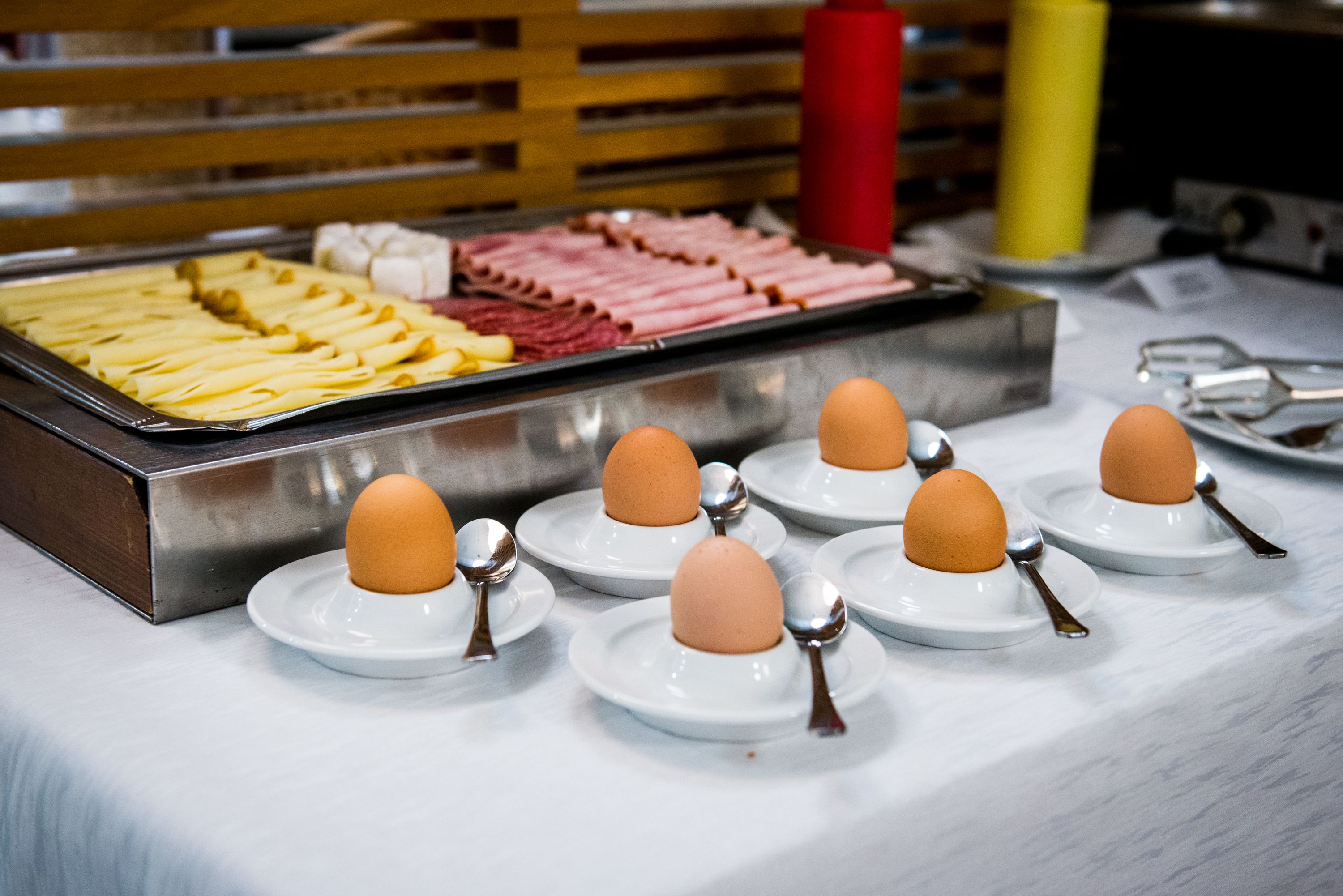 Un buffet de petit-déjeuner proposant divers aliments et des assiettes avec des œufs et des couverts.